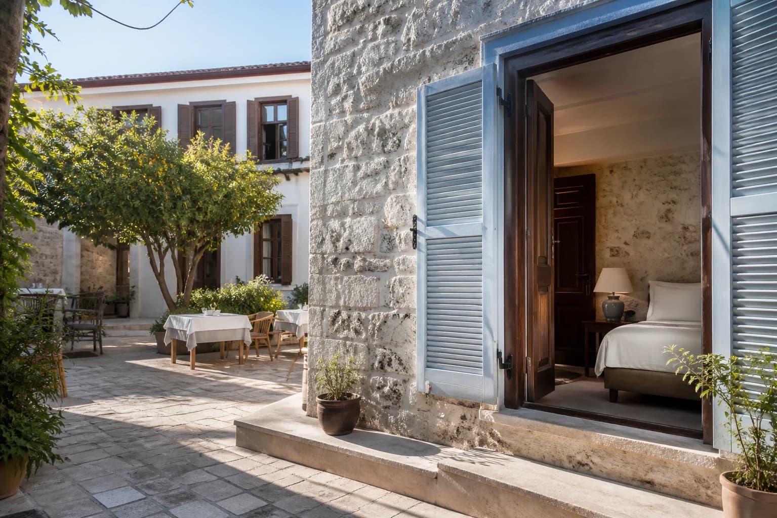 Lodos House taş avlusu ve odaya açılan mavi panjurlar